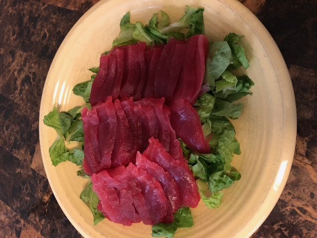 Fresh ahi sashimi plated over lettuce